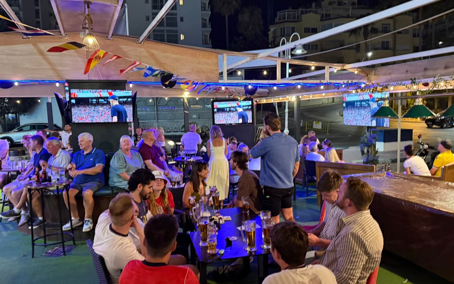 A big group enjoying drinks together on the terrace at MT Pockets, Puerto Marina